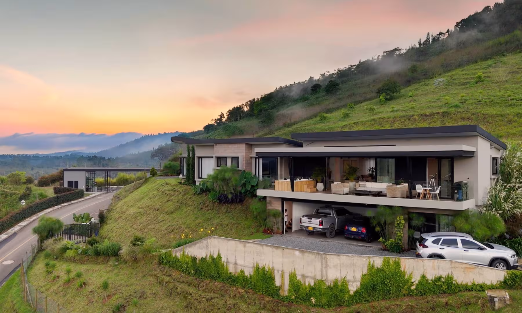 Casa campestre moderna en ladera con terraza y parqueadero al atardecer, Guarne, Oriente Antioqueño