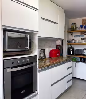 Cocina integral moderna con horno empotrado y alacena funcional