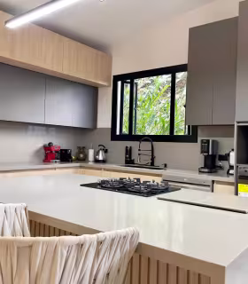 Cocina con isla, estufa empotrada y acabados modernos en casa campestre de lujo.