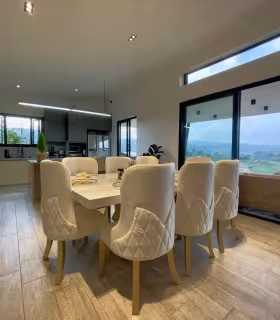 Comedor y cocina integral abierta en ambiente social moderno y luminoso.