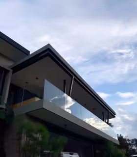 Fachada principal de casa campestre en venta con balcon panoramico y garaje cubierto.
