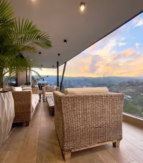 Lounge exterior con vista al valle en amplia terraza de casa campestre.