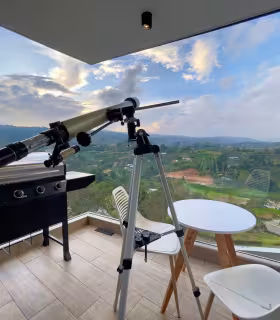 Mirador en terraza con telescopio, asador y vista panoramica al valle.
