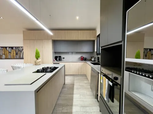 Cocina abierta integrada al comedor en concepto de espacio social amplio.