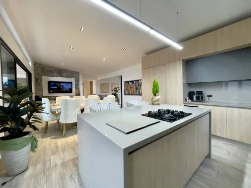 Cocina y zona social integradas con isla central y vista interior elegante.