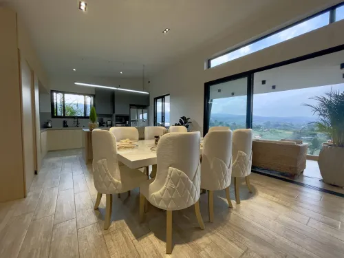 Comedor y cocina integral abierta en ambiente social moderno y luminoso.