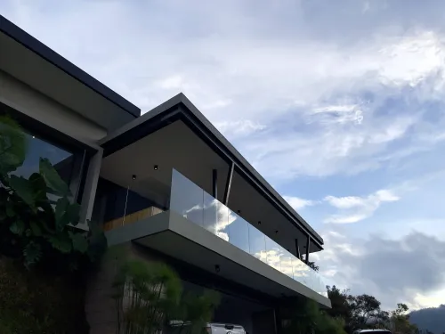 Fachada principal de casa campestre en venta con balcon panoramico y garaje cubierto.