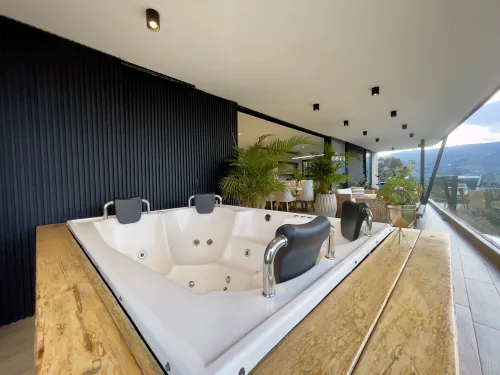 Jacuzzi en terraza cubierta con vista panoramica en casa campestre de lujo.