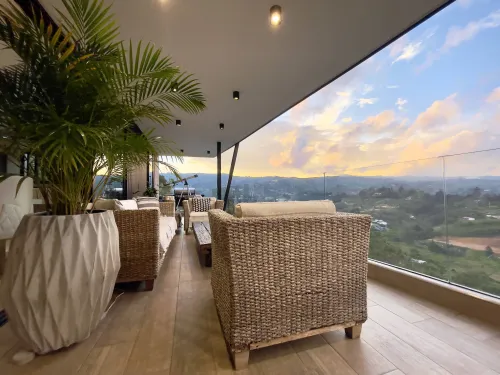 Lounge exterior con vista al valle en amplia terraza de casa campestre.