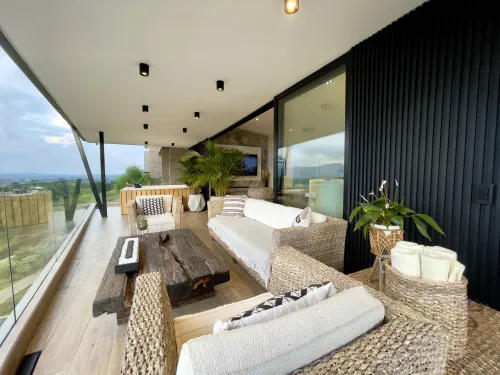 Terraza cubierta con muebles de exterior y ambiente social campestre.