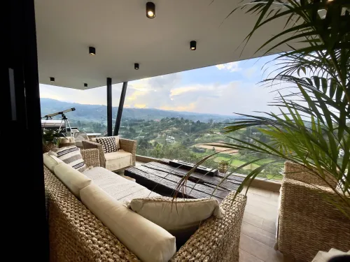 Terraza cubierta con sala exterior y vista panoramica en casa campestre en venta.